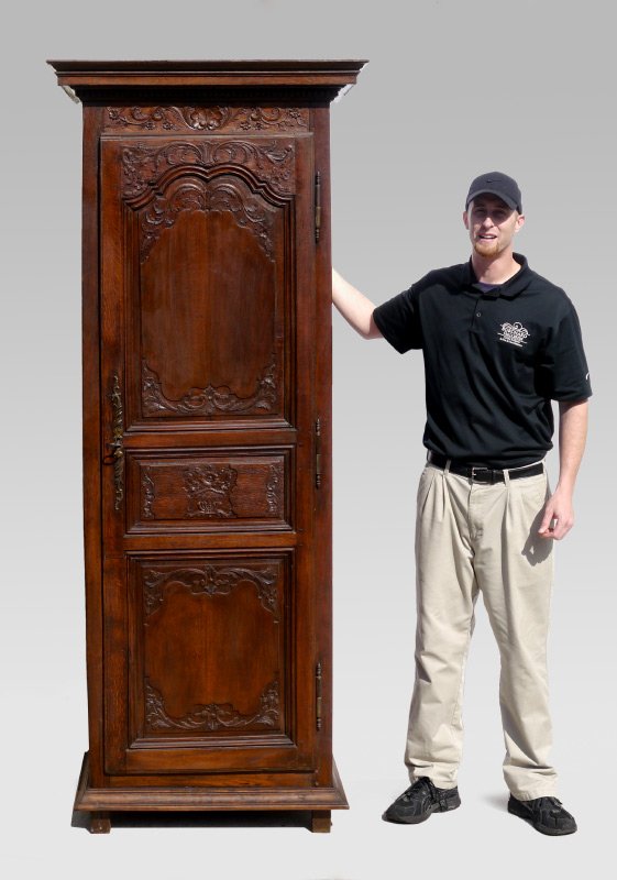 TALL CARVED BLIND CUPBOARD: TALL CARVED BLIND CUPBOARD: Stepped pediment with dentil molding, carved foliate scroll crest with shell. Single full length doer decorated with carved foliate scrolls in panels, on 4 feet, 5 interior