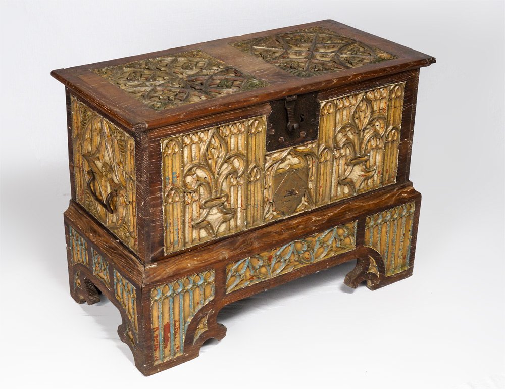 EARLY CARVED DECORATED SACRISTY CHEST: EARLY CARVED DECORATED SACRISTY CHEST: Carved polychrome decorated panels in hinged lid, sides and base featuring architectural, geometric, fleur de lis, and shield decoration. Shaped skirt, iron hard