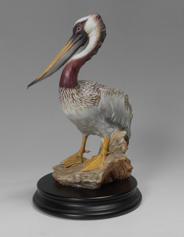 KAISER OF GERMANY PORCELAIN PELICAN SCULPTURE: KAISER OF GERMANY PORCELAIN PELICAN SCULPTURE: "The Brown Pelican" made by Giusppe Tagliariol, hand painted, 648/1200. Comes with wooden stand. 11 3/4"h without stand. Overall in very good condition.