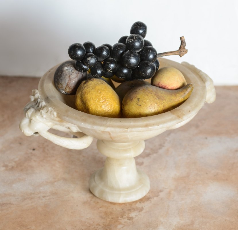 8 PC STONE FRUIT IN ALABASTER BOWL: ITALIAN CARVED ALABASTER LION HEAD COMPOTE WITH STONE FRUIT: 8 pieces of Italian carved stone fruit includes banana, grapes, peach, pear, apple, plum, fig, and a large lemon. They all rest in a carved