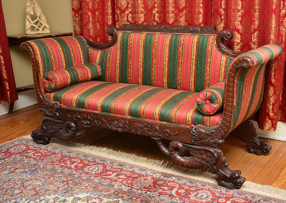 HIGHLY CARVED 19TH CENTURY TRANSITIONAL SOFA: HIGHLY CARVED 19TH CENTURY TRANSITIONAL SOFA: Richly carved and shaped frame, circa early to mid-19th century. Northwind masqueron crest rail with scrolled foliate accents, scroll arm supports carved 