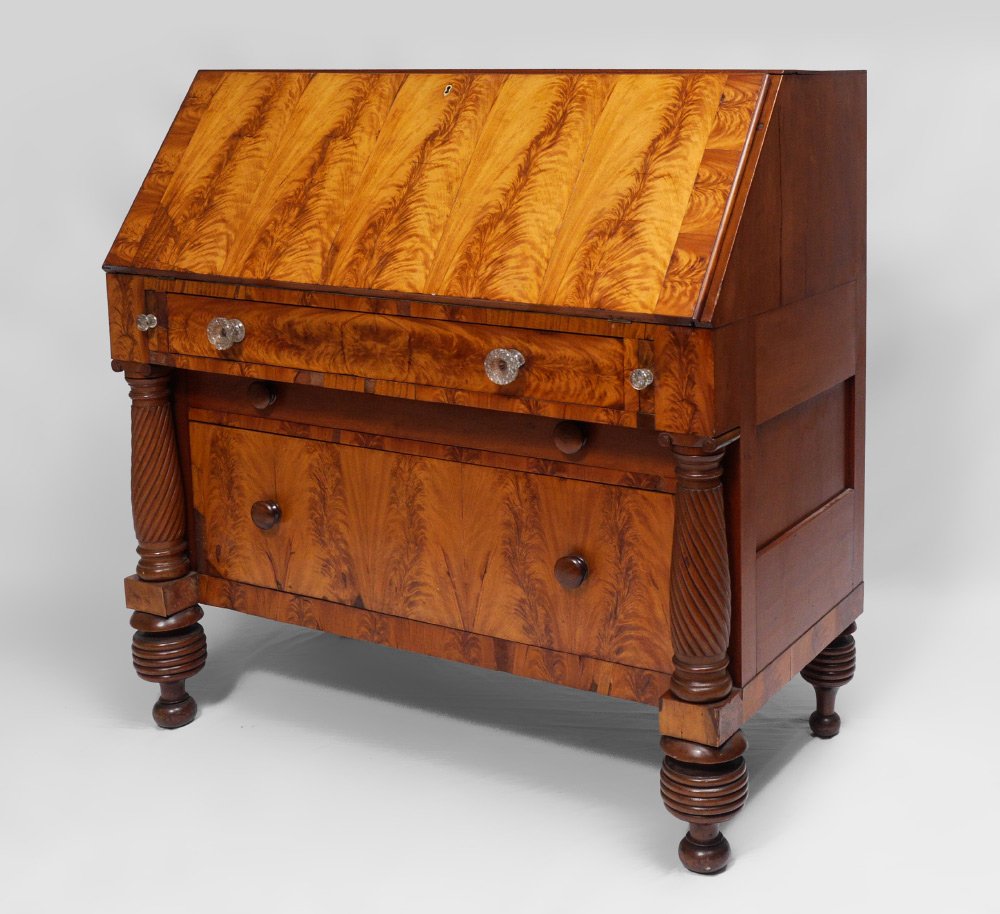 ANTIQUE DROP FRONT TIGER MAPLE DESK: ANTIQUE DROP FRONT TIGER MAPLE DESK: Tiger maple bookmatched veneers, slant front opens to 8 graduated drawers, pigeon holes and storage, green felt. Single drawer with glass pulls over deep drawer wi