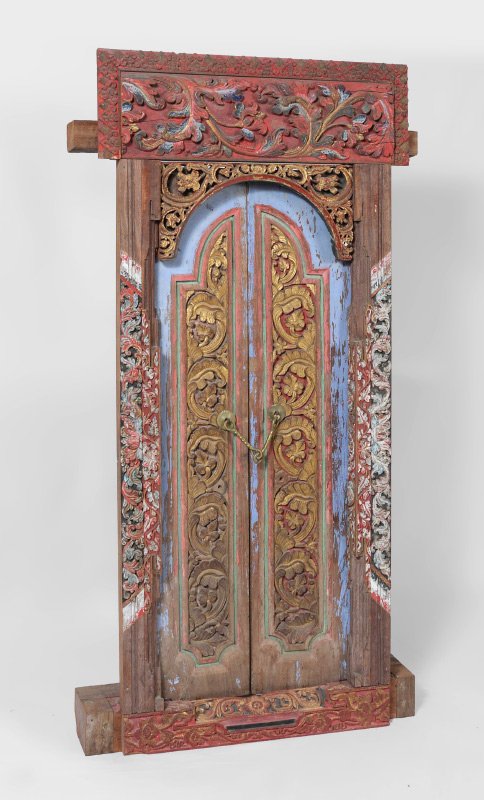 NEPALESE CARVED POLYCHROME PAINT DECORATED WINDOW: NEPALESE CARVED POLYCHROME PAINT DECORATED WINDOW: Polychrome paint decorated, frame and doors with carved foliate motifs. Brass handles, overall with support 62 1/2" h. x 33 3/4" x 5 3/4".