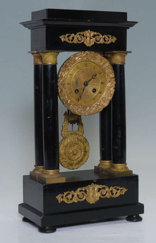FRENCH EBONIZED WOOD PORTICO CLOCK: FRENCH EBONIZED WOOD PORTICO CLOCK: Ebonized wood pediment, columns and base with ormolu accents. Gilt bronze dial with Roman numerals, unmarked French time and strike movement, overall measures 15 3/