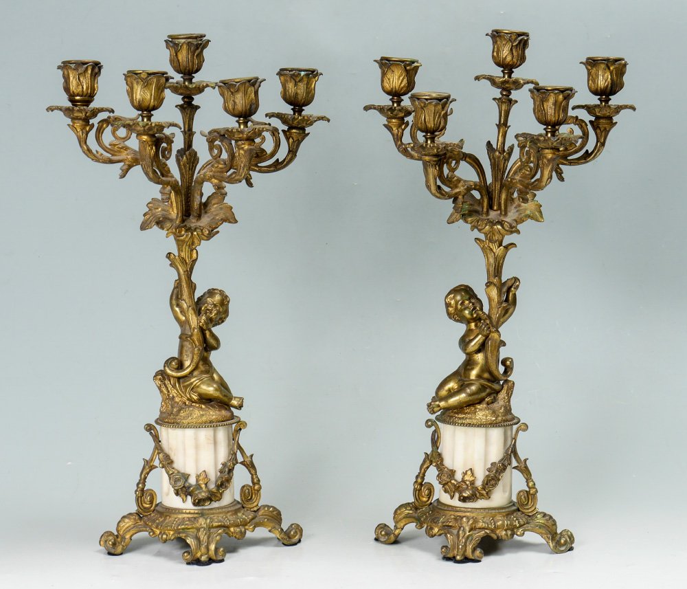 PAIR GILT BRONZE FIGURAL PUTTI CANDELABRA: PAIR GILT BRONZE FIGURAL PUTTI CANDELABRA: Most likely a clock garniture set, each with figural seated figural putti holding 5 light candelabrum over fluted alabaster body, foliate motif base. Obscure