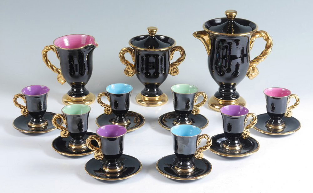 MARIUS GIUGE, VALLAURIS FRENCH COFFEE SET: MARIUS GIUGE, VALLAURIS FRENCH COFFEE SET: Coffee pot, cream pitcher and covered sugar with 8 cups and saucers. Featuring a gilt rope twist handles and accents on a striking black ground with multi-co
