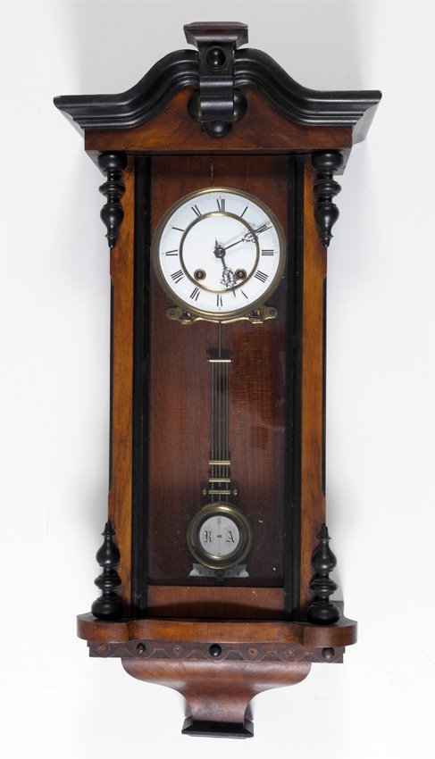 CARVED GERMAN BIEDERMEIER STYLE WALL CLOCK: CARVED GERMAN BIEDERMEIER STYLE WALL CLOCK: Biedermeier style walnut case with shaped pediment and applied decorations. Porcelain dial with Roman numerals, Lenzkirch key wind and pendulum time and str
