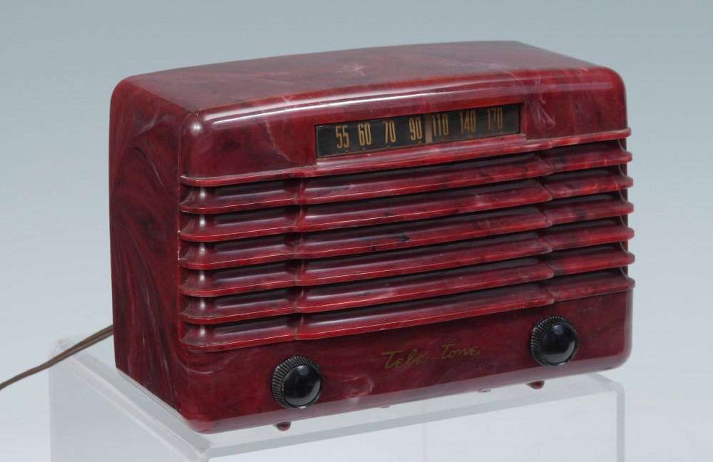 TELE-TONE MODEL 157 MARBLEIZED RED RADIO: TELE-TONE MODEL 157 MARBLEIZED RED RADIO: Marbleized red plastic case with shaped front, AM only dial, 2 knobs. Partial back, measures 6'' h. x 8 3/4''x 4 1/4''.