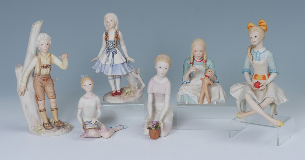 6 PIECE CYBIS PORCELAIN FIGURES: 6 PIECE CYBIS PORCELAIN FIGURES: Assembled collection of 6 total to include 1) Girl sitting on stool with apple, 7 3/4" h. x 5" x 3 3/4". 2) Girl in German dress standing, 7" h. 3) Boy in lederhosen s