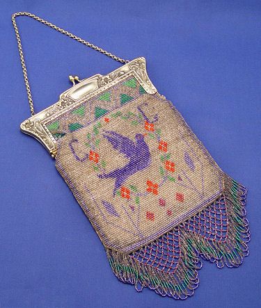 VINTAGE BEADED PURSE BLUE BIRD: VINTAGE BEADED PURSE: Floral embossed frame, brightly colored beaded body with a blue bird motif with latticed fringe. Calf leather interior. 12"l. x 7"w., excluding the chain link handle. No makers m