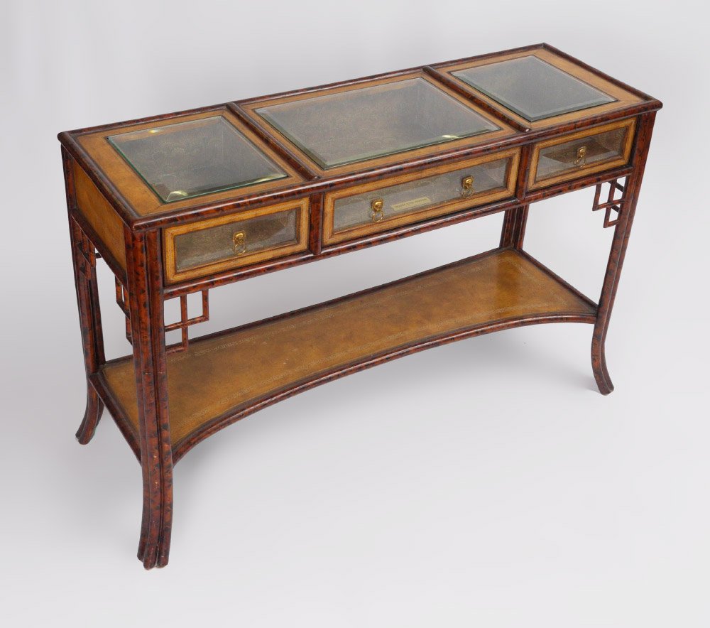 MAITLAND SMITH VITRINE HALL TABLE: MAITLAND SMITH VITRINE HALL TABLE: Top with 3 sections, beveled glass tops and drawer fronts, lined interior, faux bamboo frame, embossed leather open lower shelf, shaped legs. Overall measures 32 3/4
