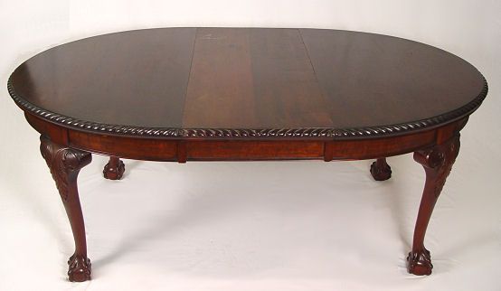OVAL MAHOGANY BALL AND CLAW FOOT DINING TABLE: OVAL MAHOGANY BALL AND CLAW FOOT DINING TABLE: Gadroon carved rim, crank mechanism to allow expansion for the leaf (included). 28" h, 52 1/2" l x 41 1/2" w.