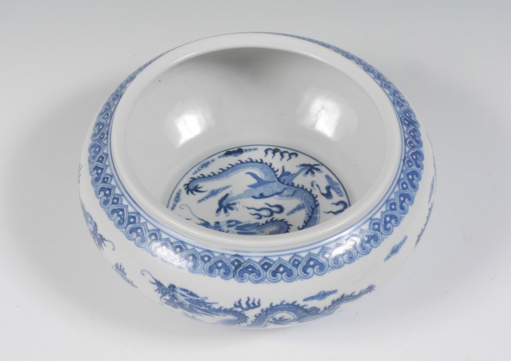 JAPANESE BLUE & WHITE DECORATED DRAGON BOWL: JAPANESE BLUE & WHITE DECORATED DRAGON BOWL: Interior with dragon and clouds in medallion, exterior with dragons in clouds over water. Singed on base, measures 4 3/4" h. x 10 3/4".
