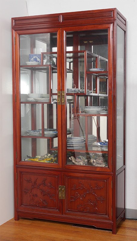 ORIENTAL MOTIF CURIO DISPLAY CABINET: ORIENTAL MOTIF CURIO DISPLAY CABINET: 2 glass doors, illuminated mirrored back interior with multi level glass shelves. 2 lower doors with carved foliate design panels, on 4 feet. Overall measures 78"