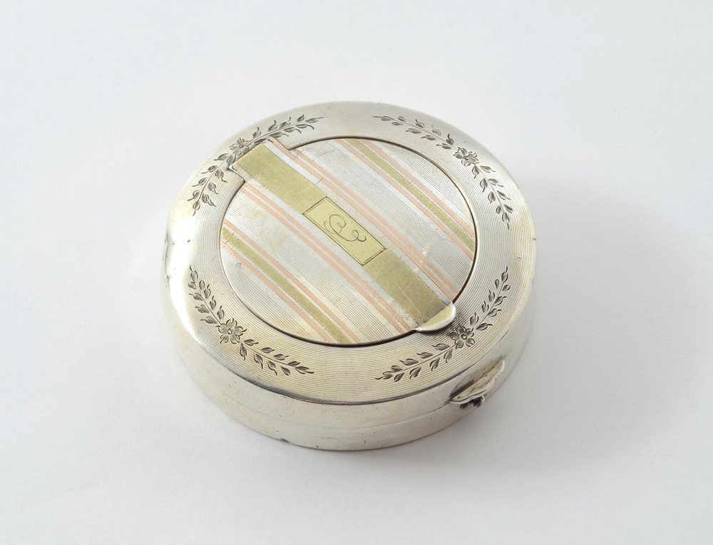 WATROUS CIRCULAR STERLING AND GOLD COMPACT: WATROUS CIRCULAR STERLING AND GOLD COMPACT: Engraved top rim, hinged pill box lid with striated mixed metal accents, monogrammed C, marked inside 14K gold inlaid. Main hinged lid opens to compact with