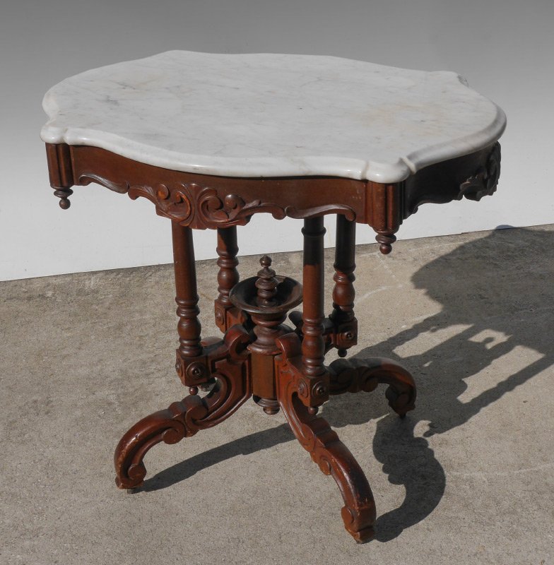 SHAPED WHITE MARBLE TOP VICTORIAN SIDE TABLE: SHAPED WHITE MARBLE TOP VICTORIAN SIDE TABLE: White beveled marble turtle top table, carved and shaped skirt, turned supports, splayed feet. Measures approx. 28 1/2" tall x 30" x 22".