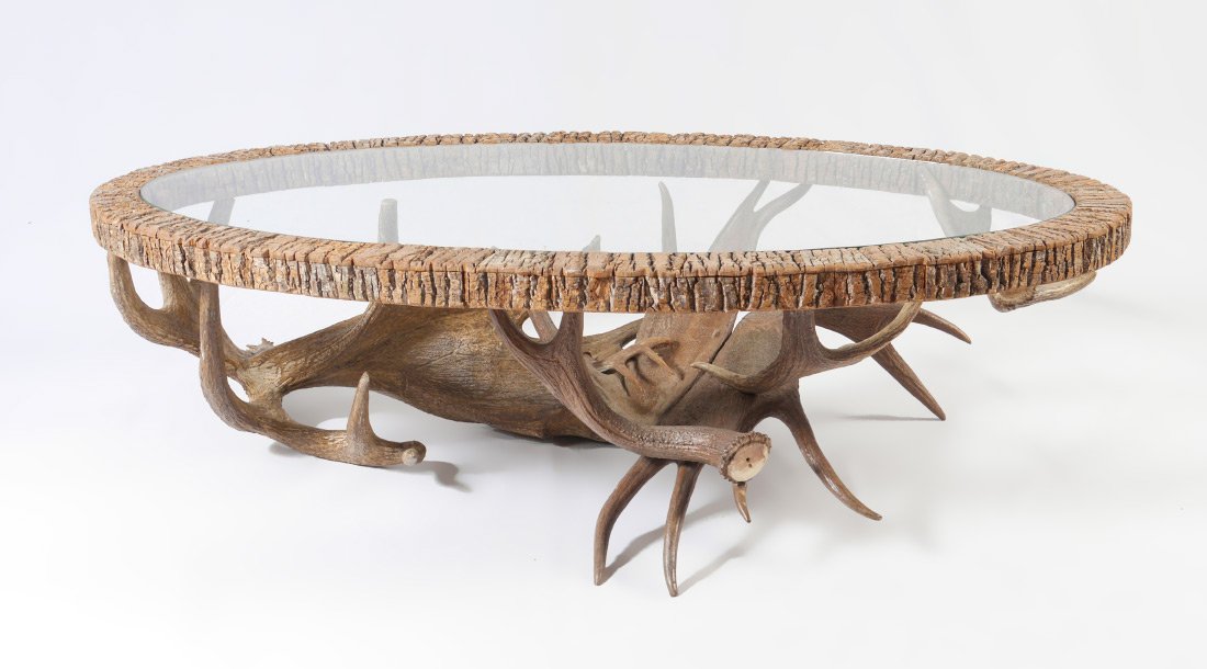 TIMPSON GALLERY MOOSE ANTLER COFFEE TABLE: TIMPSON GALLERY MOOSE ANTLER COFFEE TABLE: Moose antler base, carved oval wood top with natural edges, glass insert. 17" h. x 60 1/2" x 30 3/4".