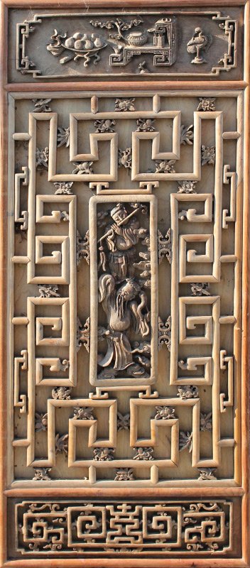 LARGE ORIENTAL WALL CARVING: LARGE ORIENTAL WALL CARVING: All decoration applied to backboard, top panel with carved interior genre scene, middle panel with musician standing atop another, balance with carved floral and geometric