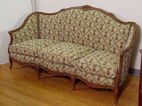1930'S FRENCH STYLE CARVED WALNUT SOFA: 1930'S FRENCH STYLE CARVED WALNUT SOFA: Gracefully carved and shaped frame with cabriole legs, recently upholstered in a cheery pineapple print.