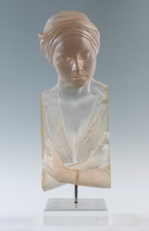 MARC SIJAN ACRYLIC SCULPTURE: MARC SIJAN ACRYLIC SCULPTURE: Toned acrylic bust of a woman wearing a headwrap and blouse, clear Lexan base, no visible signature on bust or base. Overall measures 26" h. x 9" x 12.
