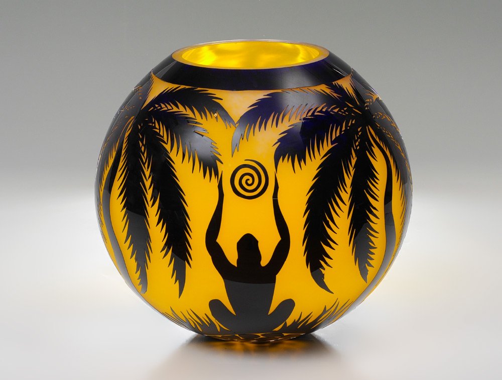 DUNCAN MCCLELLAN CELEBRATION ART GLASS VASE: MCCLELLAN, Duncan, (American, 20th Century): ''Celebration of Life Force'', overlay sand carved art glass vase featuring palm trees, seated figure below a spiral sun. Signed on base, overall measures