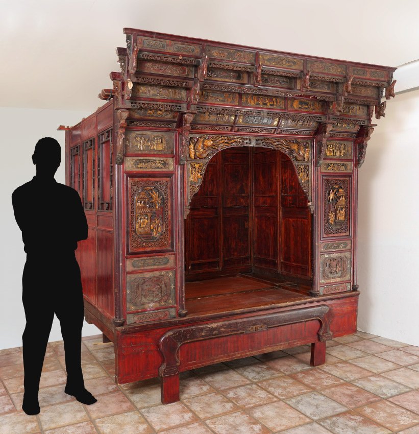CHINESE CARVED OPIUM / WEDDING BED: CHINESE CARVED OPIUM / WEDDING BED: Front profusely carved in panels with genre scenes, pierce work, gilt accents and red lacquer in areas. 3 panel sides and 5 panel back with floral windows, addition