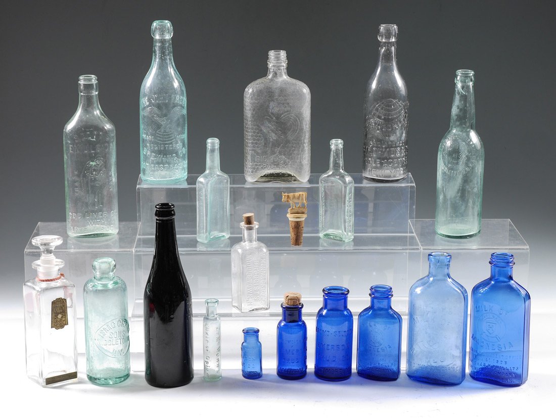 COLLECTION OF ASSORTED ANTIQUE BOTTLES:: COLLECTION OF ASSORTED ANTIQUE BOTTLES: An assembled collection of 18 bottles to include Chickencock Whiskey, Pabst, bitters, Milk of Magnesia and more. Tallest bottle measures 9 1/4''.