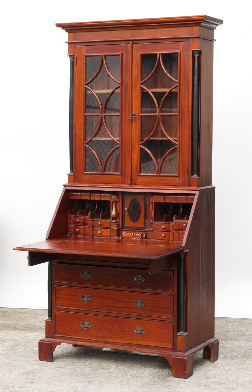 CHERRY SECRETARY BOOKCASE: CHERRY SECRETARY BOOKCASE: 2 glass door bookcase top with curved diamond pattern fretwork, ebonized columns, 2 interior wood shelves. Slant front secretary, interior with valence top drawers, pigeon h
