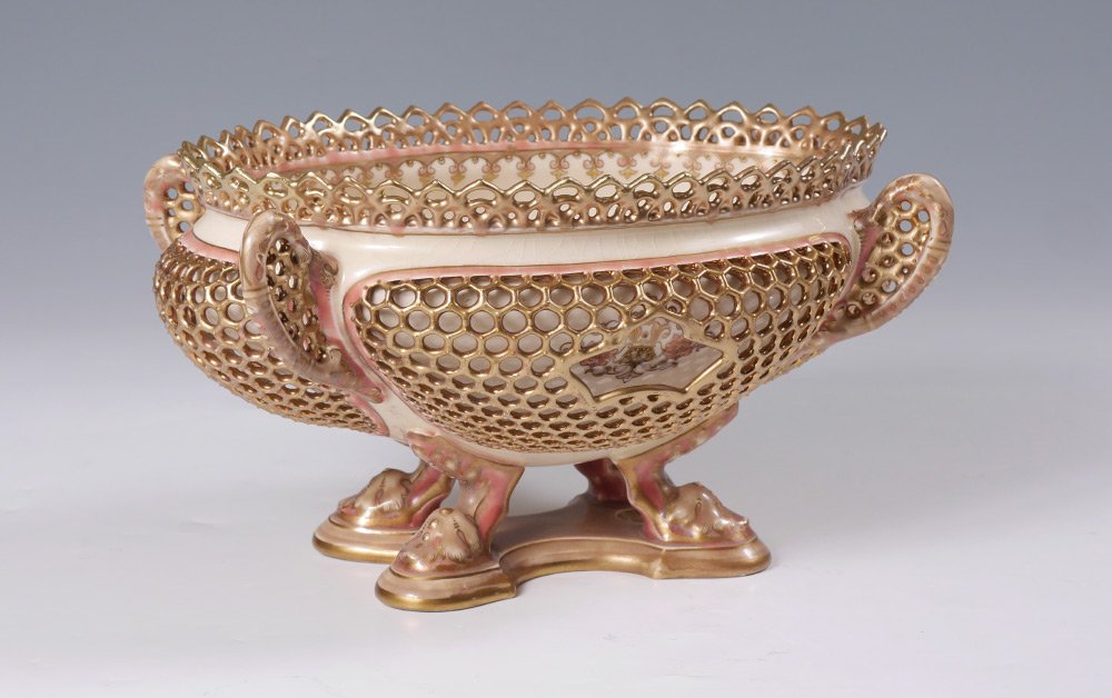 ZSOLNAY POTTERY RETICULATED CENTER BOWL: ZSOLNAY POTTERY RETICULATED CENTER BOWL: Center bowl with reticulated rim, handles and applied sides. Floral decorated interior and on body, 4 legs, impressed marks on base. Overall measures 7" h. x 1