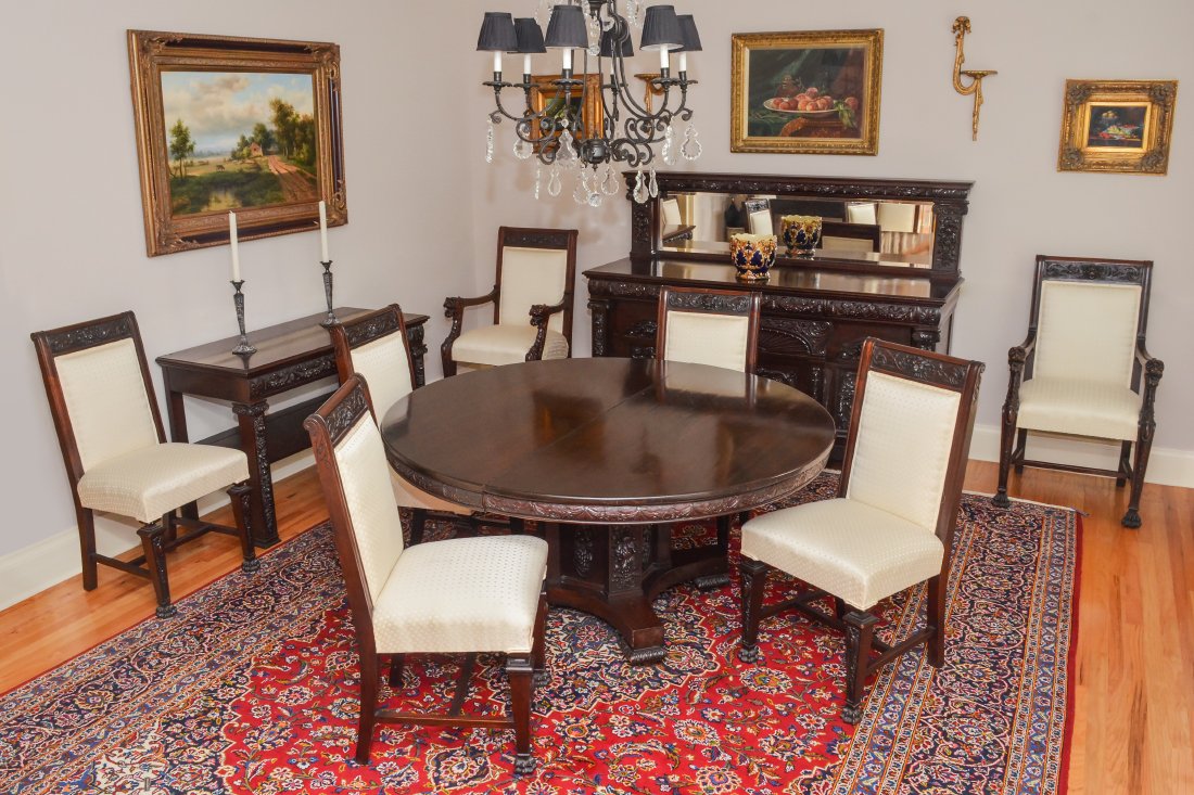 CARVED 10 PIECE MAHOGANY DINING ROOM SET: CARVED 10 PIECE HORNER (ATTRIB) MAHOGANY DINING ROOM SET: 10 matching richly carved pieces, to include 1) Round dining table with carved skirt and pedestal base, on 4 splayed feet, overall 30 1/2" h.