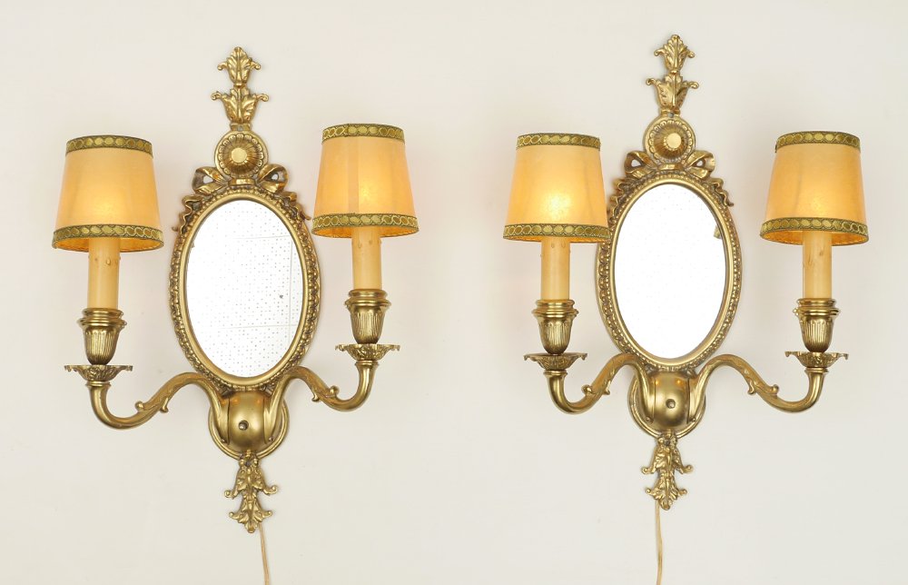 PAIR OF GOLD DECORATED FRENCH WALL SCONCES: PAIR OF GOLD DECORATED FRENCH WALL SCONCES: Pair of gold decorated cast metal double light electric sconces with center mirror, garland and foliate upper and lower finials. Overall measure 23 1/5" x 1