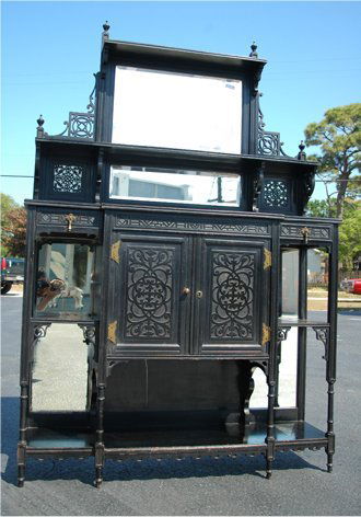 EDWARDIAN VICTORIAN ETAGERE: EDWARDIAN VICTORIAN ETAGERE: Pierce and relief carved dark mahogany with central beveled mirror. Full length open shelf, open display and cabinet drawers. 6'h. x 48 1/2''.