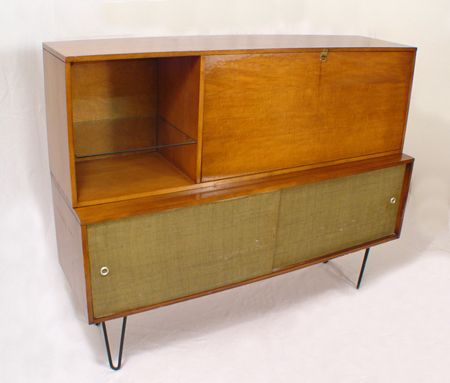 PAUL McCOBB PLANNER GROUP CONSOLE SERVER: PAUL McCOBB "PLANNER GROUP" CONSOLE SERVER: Maple two part cabinet on bent iron legs. The lower portion has sliding doors covered in burlap design canvas (peeling at corners). The upper section has fa
