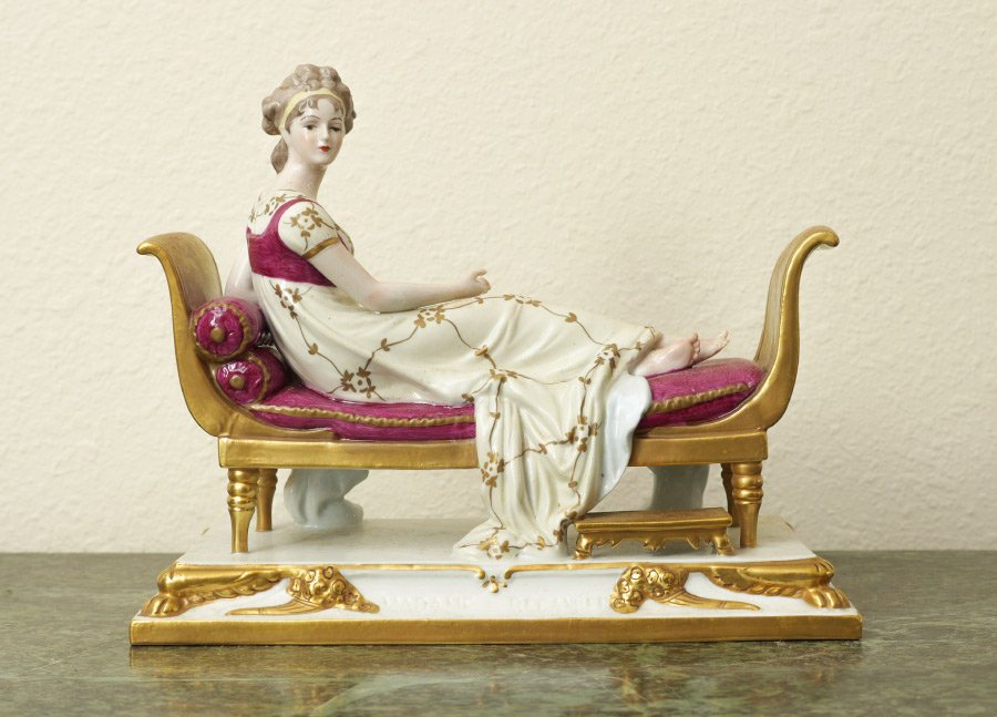 SITZENDORF MADAME RECAMIER PORCELAIN FIGURE: SITZENDORF MADAME RECAMIER PORCELAIN FIGURE: Figure of "Madame Recamier" after Jeanne Francoise Julie Adelaid Recamier, Sitzendorf mark on side. Overall measures 7 1/2" h. x 9 1/2" x 5 1/4".
