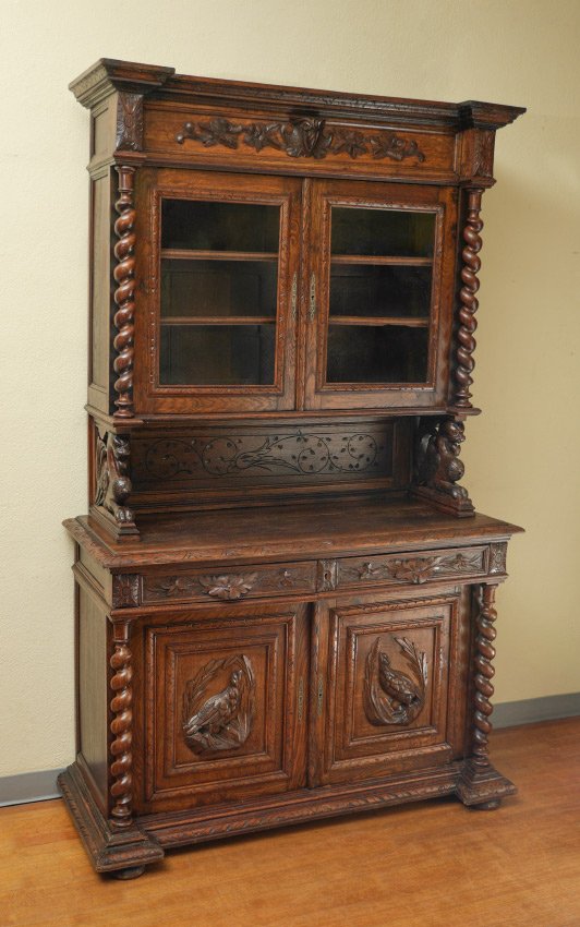 GOTHIC REVIVAL CARVED OAK HUTCH: GOTHIC REVIVAL CARVED OAK HUTCH: Carved pediment with applied oak leaf and shield crest, 2 glass doors with 2 internal shelves, barley twist columns, figural griffon carved supports. Base with 2 drawe