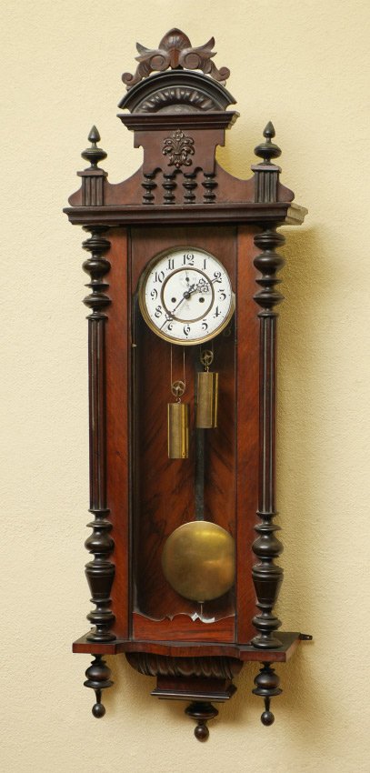 GUSTAV BECKER CARVED REGULATOR WALL CLOCK: GUSTAV BECKER CARVED REGULATOR WALL CLOCK: Removable carved pediment, door with turned and fluted half columns, lower turned finials. Porcelain dial marked with Gustav Becker anchor mark. Double weigh