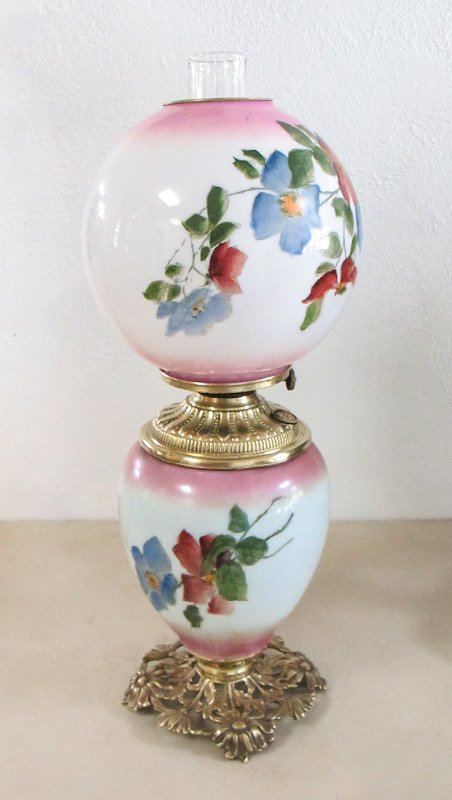FLORAL GONE WITH THE WIND LAMP: FLORAL GONE WITH THE WIND LAMP: Milk glass shade and base with painted floral design, pink accents, floral motif brass base, unaltered brass reservoir, clear chimney. Base 13 1/2'' x 7 1/2'', shade 8