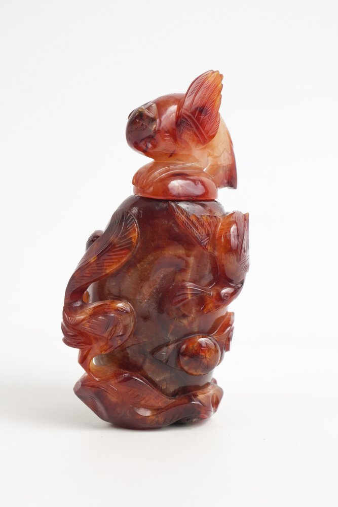 CHINESE CARVED CARNELIAN CENSOR WITH LID: CHINESE CARVED CARNELIAN CENSOR WITH LID: Lid with carved bit finial, body with carved bird, fruit and flower. Overall measures 6" h. x 3 1/2" x 2 3/4".
