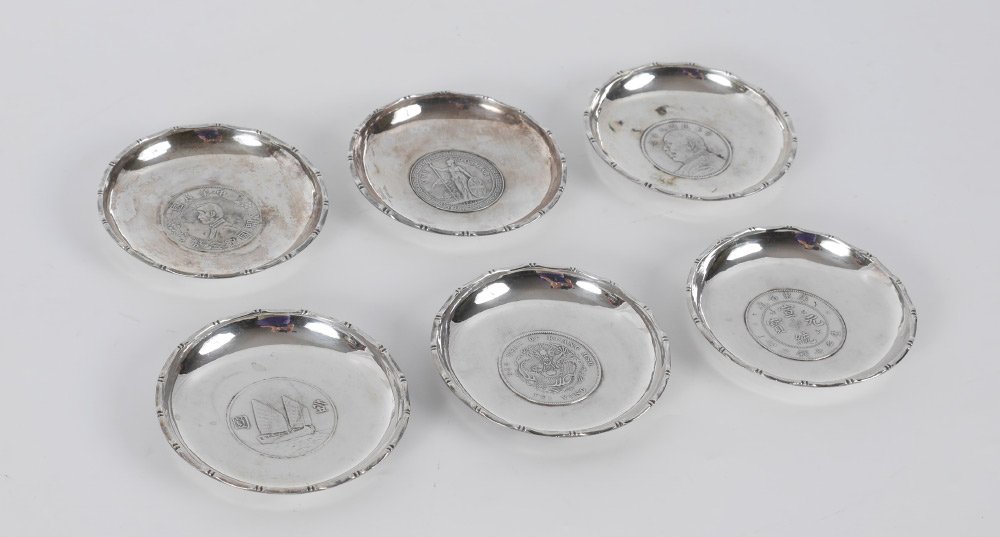 6 WAI KEE SILVER COIN DISHES 12 Troy Oz total: 6 WAI KEE SILVER COIN DISHES: 6 pieces total, each with a different inset coin at base, 1 /4" h. x 3 1/2" dia. Approx. 12.1 troy oz. inclusive of coins.