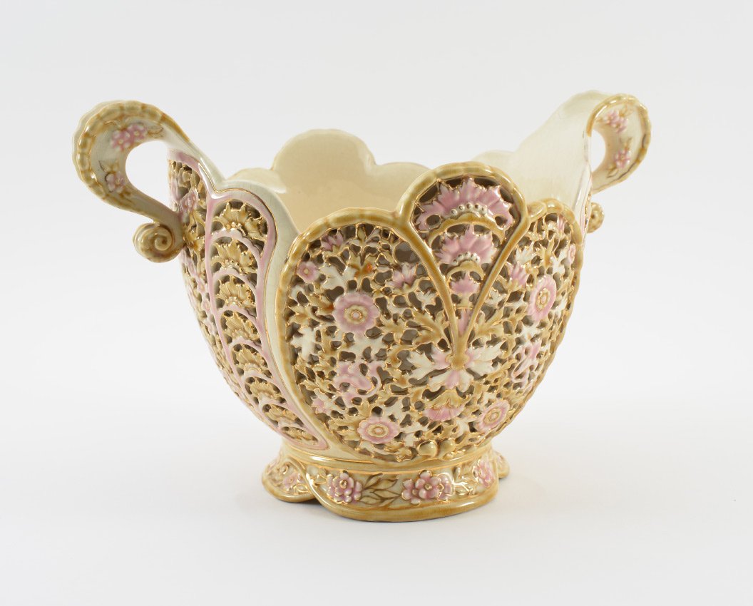 ZSOLNAY RETICULATED DOUBLE HANDLE CENTER BOWL: ZSOLNAY RETICULATED DOUBLE HANDLE CENTER BOWL: Late 19th century, scalloped rim, shaped double handles, reticulated floral motif body, impressed Zsonlay Pecs 2555 16, purple 5 steeple mark. Overall me