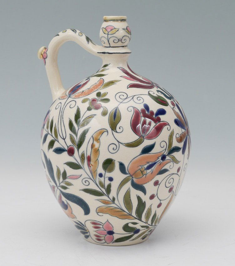 EARLY IZNIC STYLE ZSOLNAY POTTERY JUG: EARLY IZNIC STYLE ZSOLNAY POTTERY JUG: Late 19th century, cream ground with polychrome floral decoration in the Iznic style, blue Zsolnay Pecs, 5 church steeple, T.J.M. mark. Measures 9 1/4'' h. x 6 1