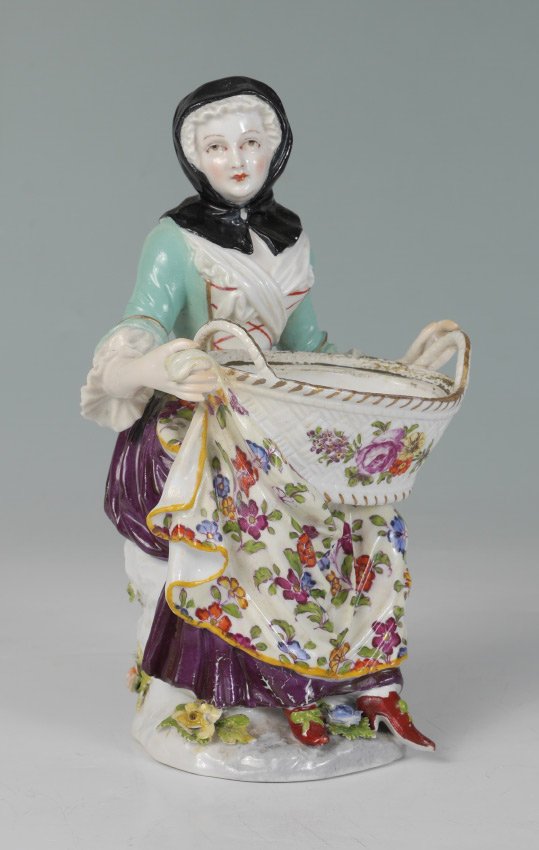 MEISSEN FIGURE OF A SEATED WOMAN WITH BASKET: MEISSEN FIGURE OF A SEATED WOMAN WITH BASKET: Figure of a seated maiden with large basket on her lap, flowers below, blue AR mark, measures 8'' h. x 5'' x 4 1/4''.