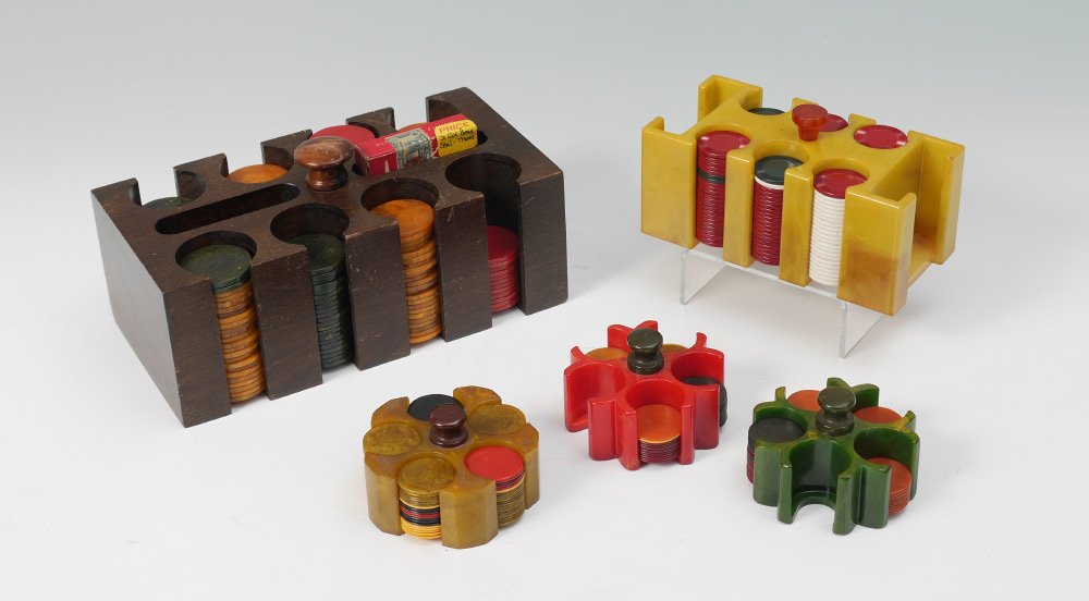3 BAKELITE POKER CHIP HOLDERS AND CHIPS: 4 BAKELITE POKER CHIP HOLDERS AND CHIPS: 5 caddies total, 4 Bakelite and 1 wood, sold with an assortment of chips to include Bakelite. Largest wood holder 4 1/2" h. x 9" x 4 3/4", the three small Bake