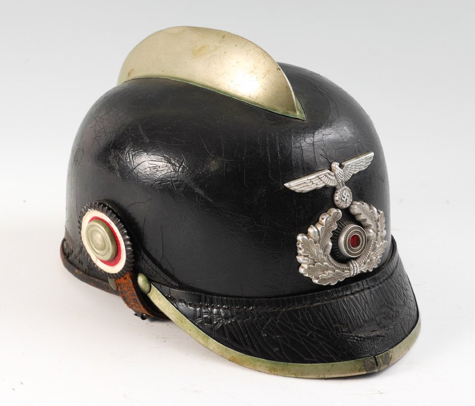 GERMAN WWII LEATHER FIRE FIGHTERS HELMET: GERMAN WWII LEATHER FIRE FIGHTERS HELMET: Leather shell, metal comb and front band, front with winged eagle and laurel wreath emblems, leather chin strap. Overall 6 1/4" h. 7" x 9 1/4".