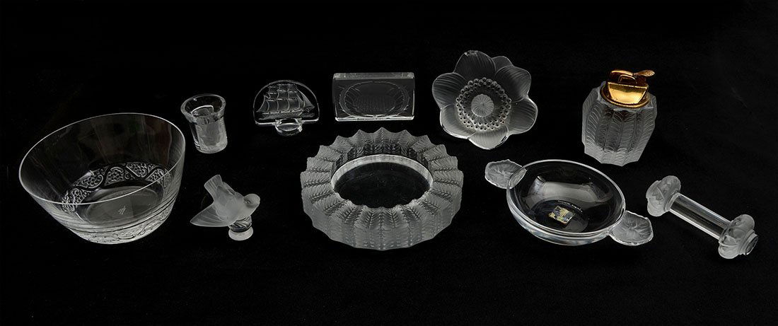 11 PIECE COLLECTION OF LALIQUE ITEMS: 11 PIECE COLLECTION OF LALIQUE ITEMS: An assembled collection of 11 Lalique crystal items to include knife rest, ashtray, bowls, paperweights, lighter, display sign and more. Ashtray measures 5 1/2''