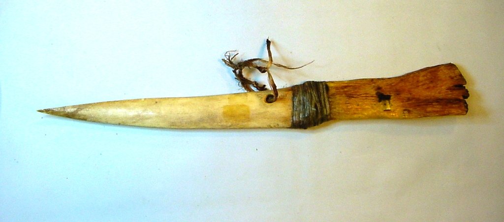OSAGE Native American Elk Bone War Dagger: All hand carved war dagger from one piece of Elk Bone. From the Osage Nation people. The tribe migrated west of the Mississippi River during the 1700's. Carved hole for mounting. Central USA. Possibly