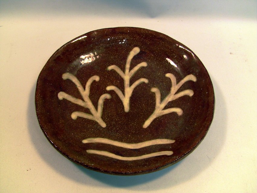 Pennsylvania Folk Art Slip Red Earthenware Plate: Thick red stoneware, with a layer of glaze on the front. Hand decorated with three stylized branches in yellowish/white slip. Came from Lancaster County, Pennsylvania. Measurements: Approx. 7.75" diam