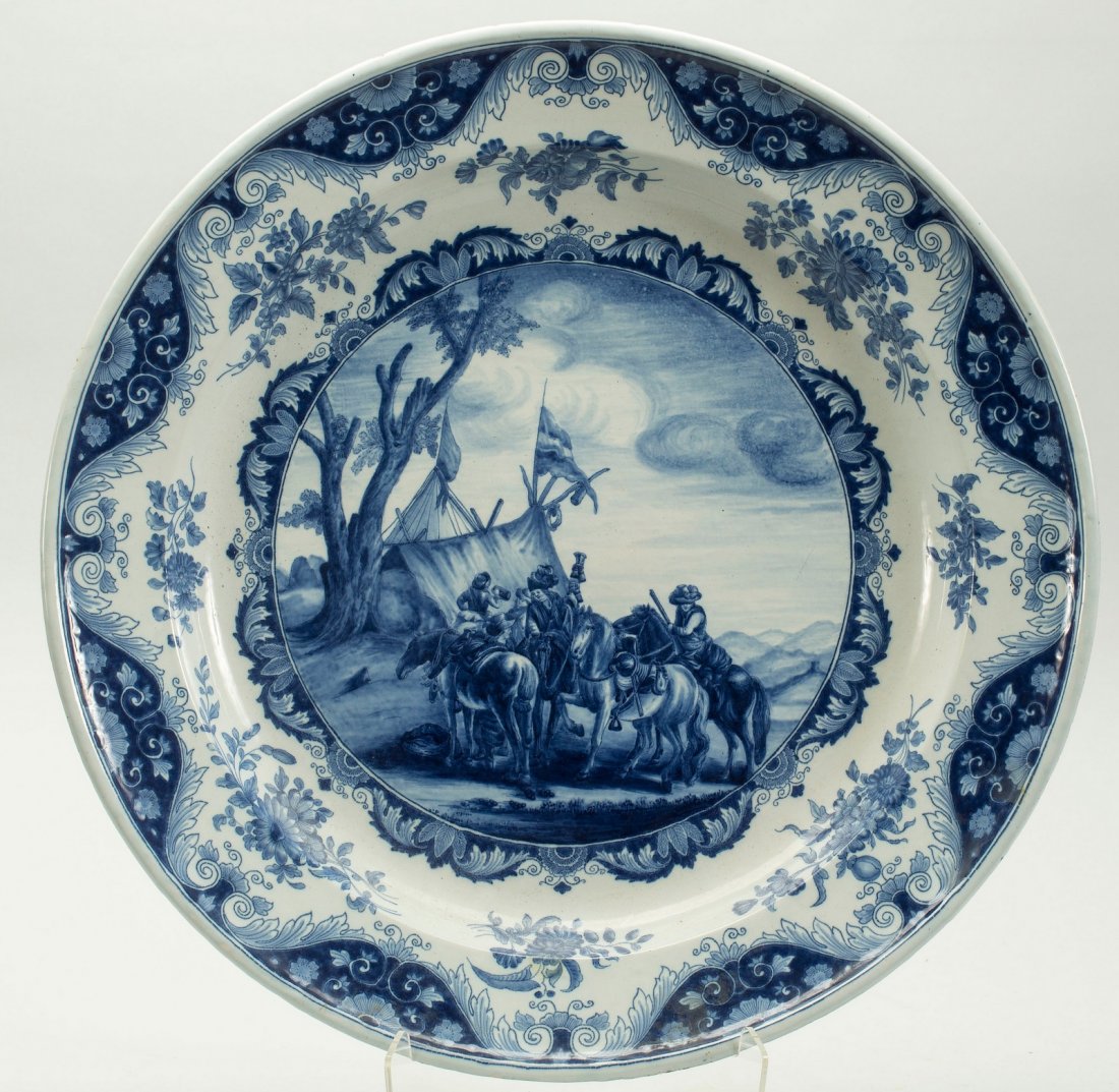 1700/1800's Large Blue & White Faience DELFT Charger: Thick faience. All hand decorated. Underglaze Cobalt Blue & White. Central medallion depicts a Military gathering scene, cased in an elaborate foliage border. Marked by hand in underglaze blue on the