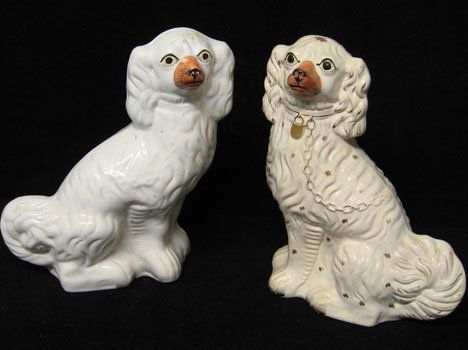 Two Staffordshire spaniels, mid. 19th c., One wit: Two Staffordshire spaniels mid. 19th c. One with gilt collar and chain and painted details the other white with painted face. H: 12 1/2 in. PROVENANCE: From the collection of Marie Evans, Alexandria,