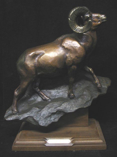 Jim Gilmore - 'Crossing the Ridge', 20th c., Sign: Jim Gilmore - 'Crossing the Ridge' 20th c. Signed on back. Bronze statue of a ram on wood base. H: 18 1/2 x W: 15 in. PROVENANCE: From the collection of Marie Evans, Alexandria, Virginia